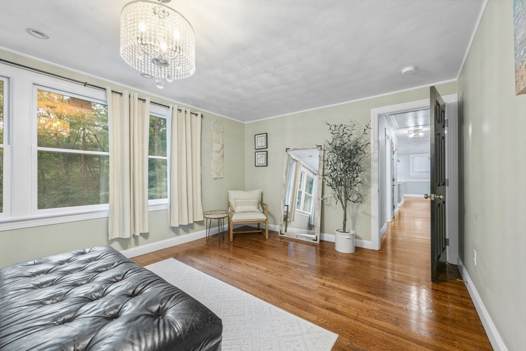 175 Central Street North Reading, MA 01864 - Photo 15 of 42 a spacious bedroom with a bed and a chandelier