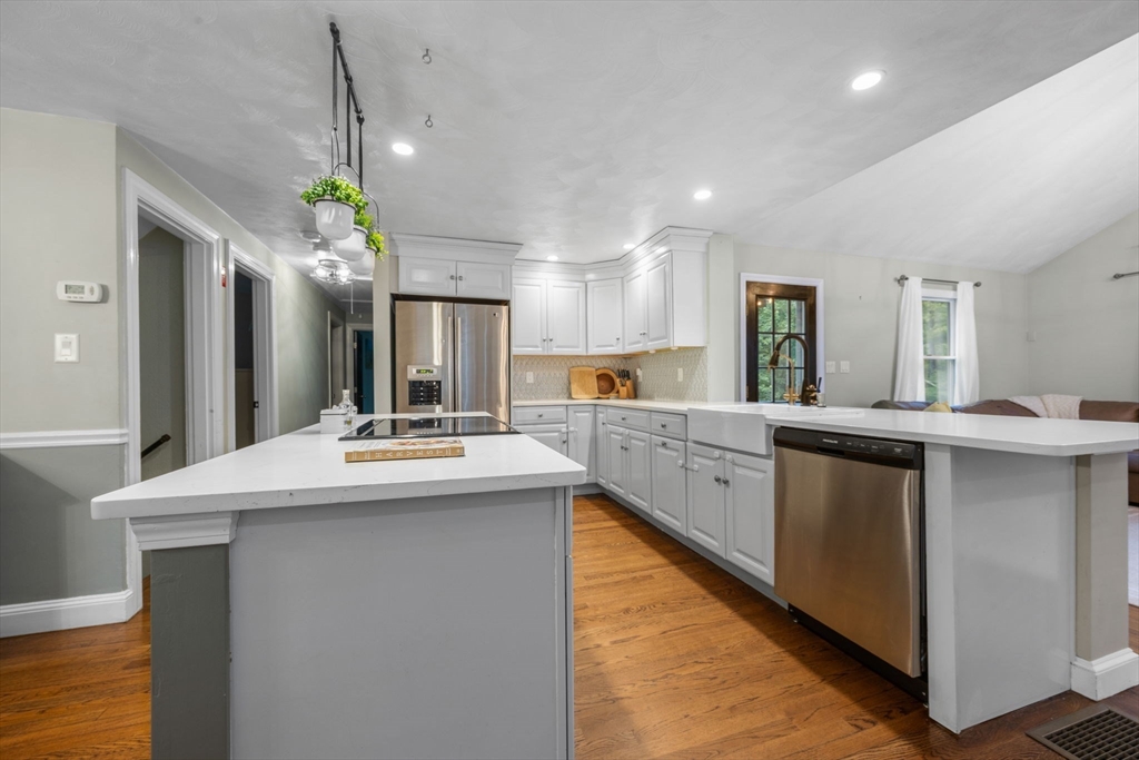 175 Central Street North Reading, MA 01864 - Photo 6 of 42 a kitchen with kitchen island granite countertop a sink cabinets and wooden floor