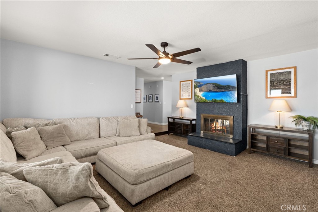 18165 Mariposa Avenue Riverside, CA 92508 - Photo 15 of 59 a living room with furniture a flat screen tv and a fireplace