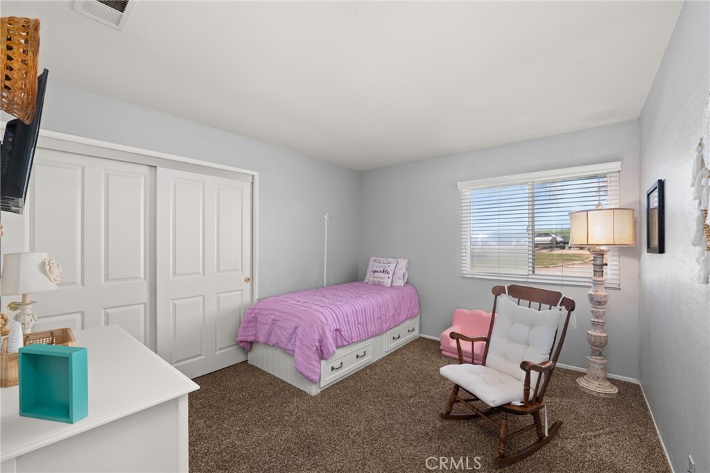 18165 Mariposa Avenue Riverside, CA 92508 - Photo 22 of 59 a bedroom with a bed a chair and potted plant on the dresser