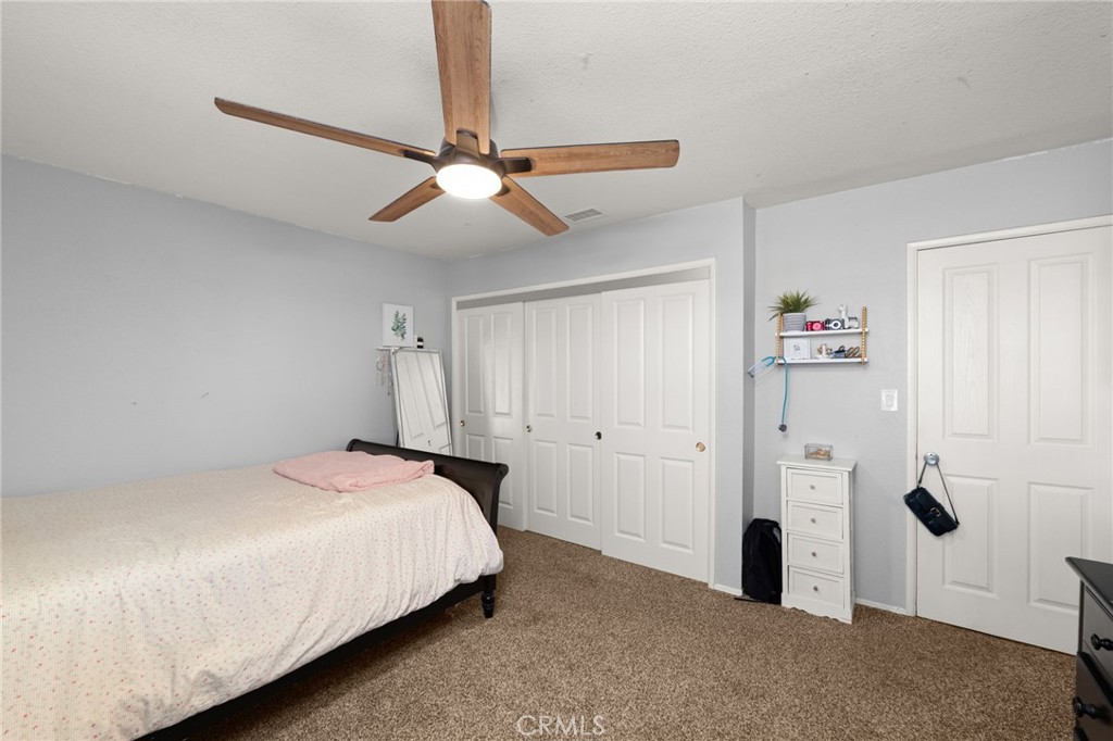 18165 Mariposa Avenue Riverside, CA 92508 - Photo 25 of 59 a bedroom with a bed and a ceiling fan