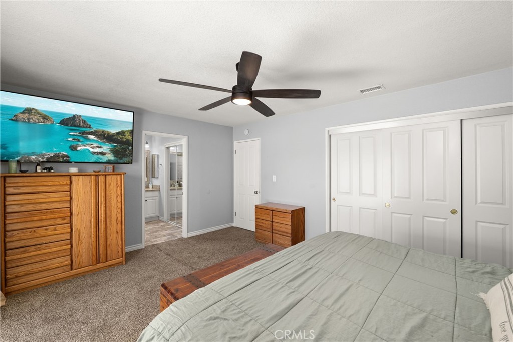 18165 Mariposa Avenue Riverside, CA 92508 - Photo 27 of 59 a bedroom with a large bed and a chandelier