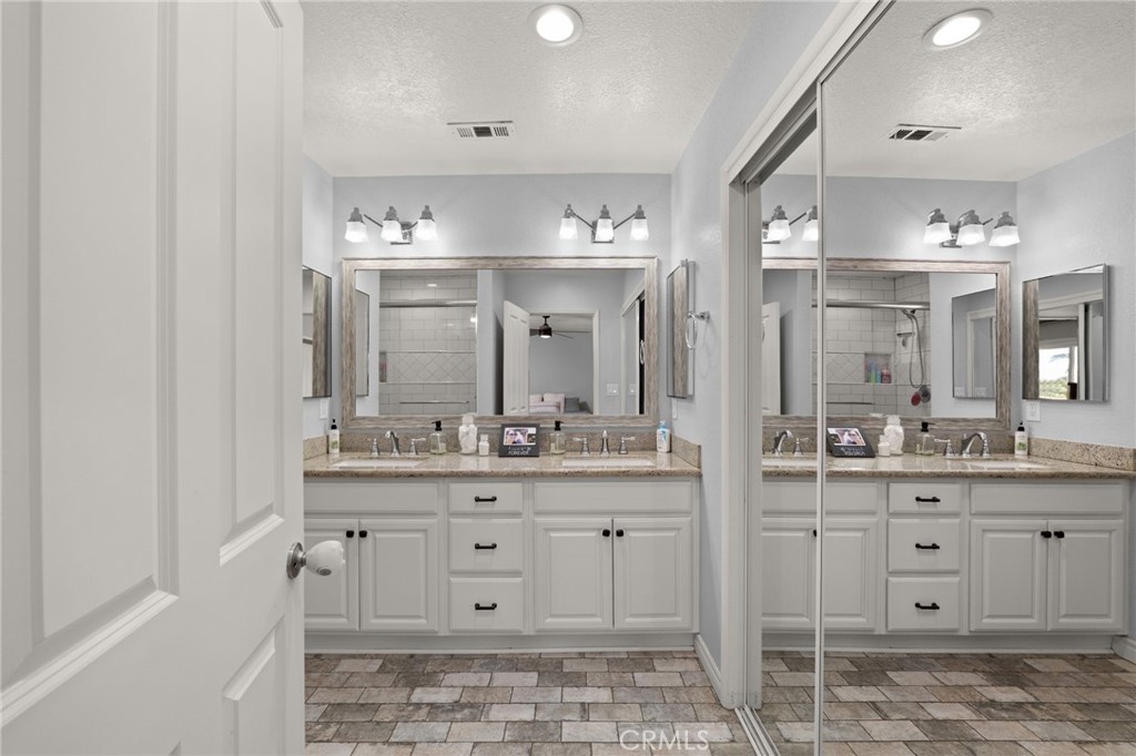 18165 Mariposa Avenue Riverside, CA 92508 - Photo 28 of 59 a bathroom with a sink a light fixture and a view of living room