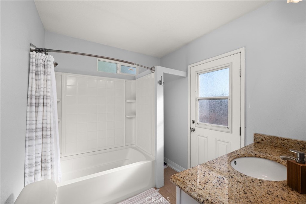 18165 Mariposa Avenue Riverside, CA 92508 - Photo 45 of 59 a bathroom with a granite countertop tub sink and mirror