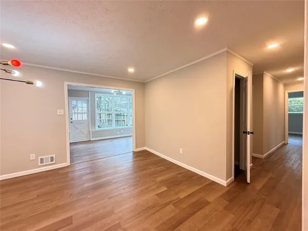 an empty room with wooden floor and windows