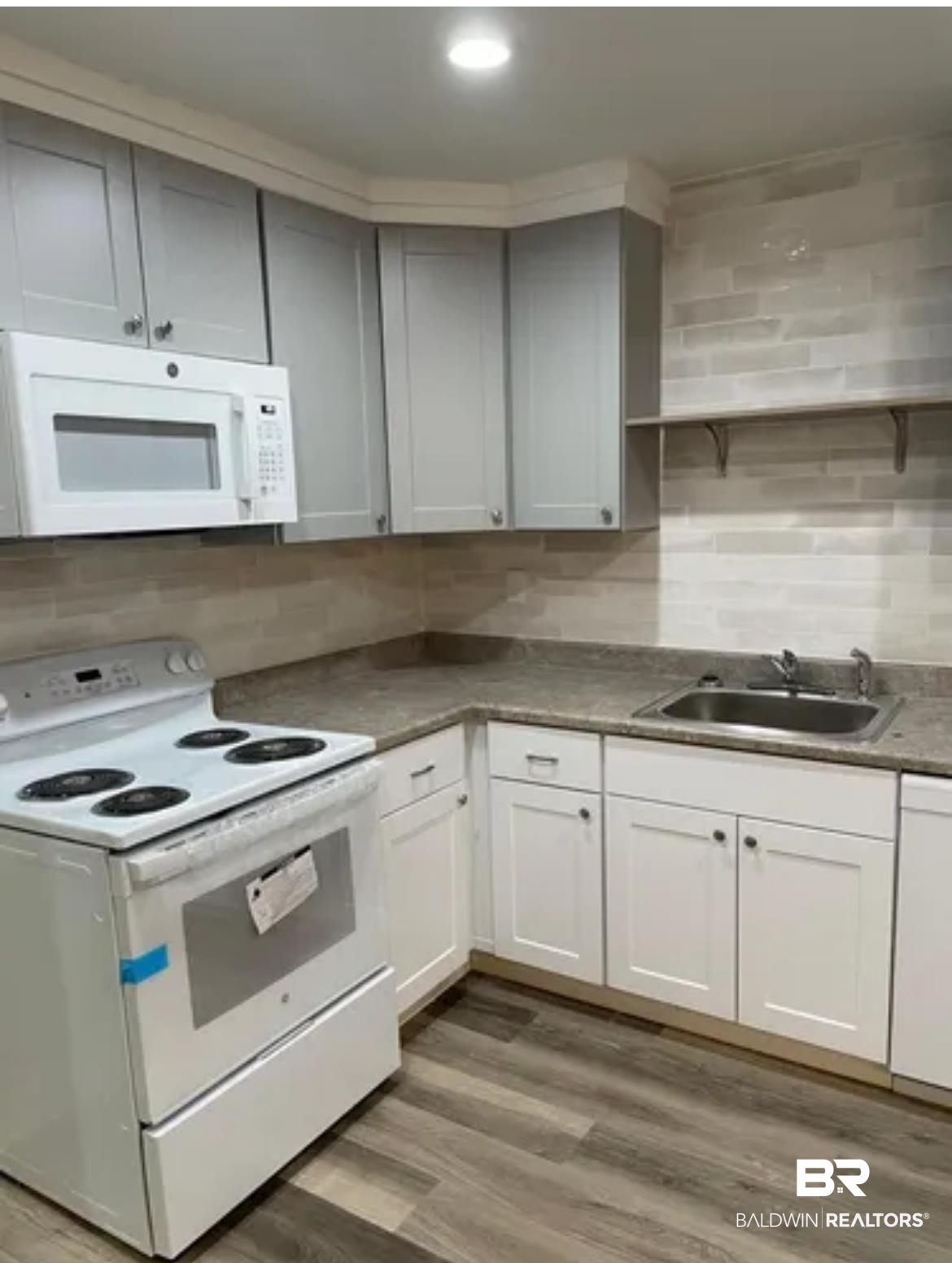 2 Canterberry Circle Foley, AL 36535 - Photo 21 of 24 Kitchen with dark countertops, white appliances, a sink, and wood finished floors