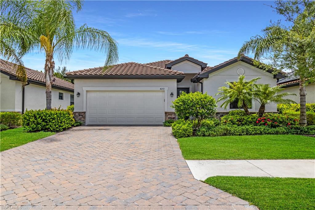 4272 Raffia Palm Circle Naples, FL 34119 - Photo 1 of 41 Mediterranean / spanish-style house featuring a garage and a front yard