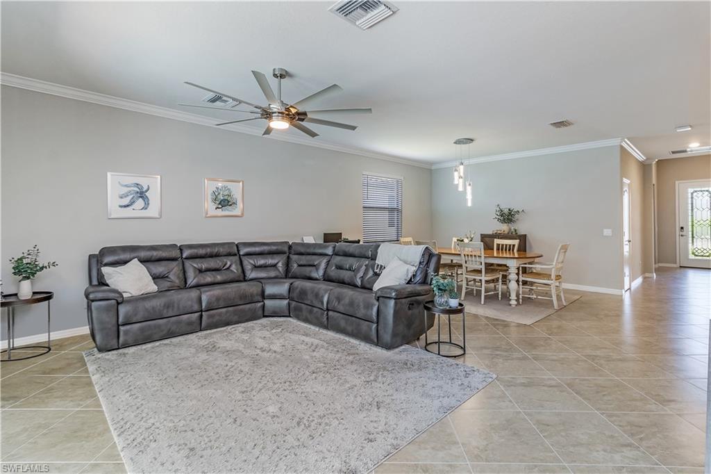 4272 Raffia Palm Circle Naples, FL 34119 - Photo 7 of 41 Living room with crown molding, ceiling fan, and light tile patterned floors