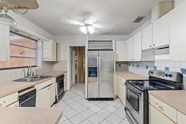 a kitchen with white cabinets and appliances