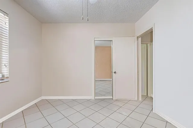 an empty room with a chandelier fan