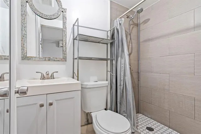 a bathroom with a sink a toilet and shower