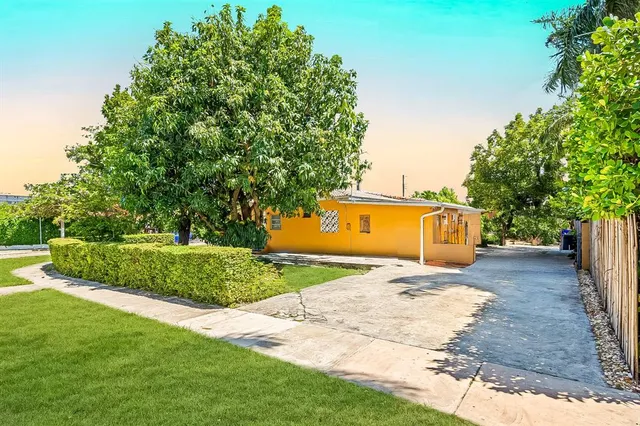 a front view of a house with a yard and trees