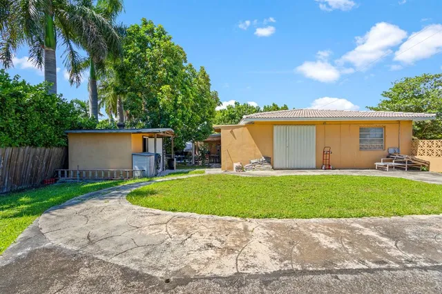 an aerial view of residential houses with outdoor space and trees all around