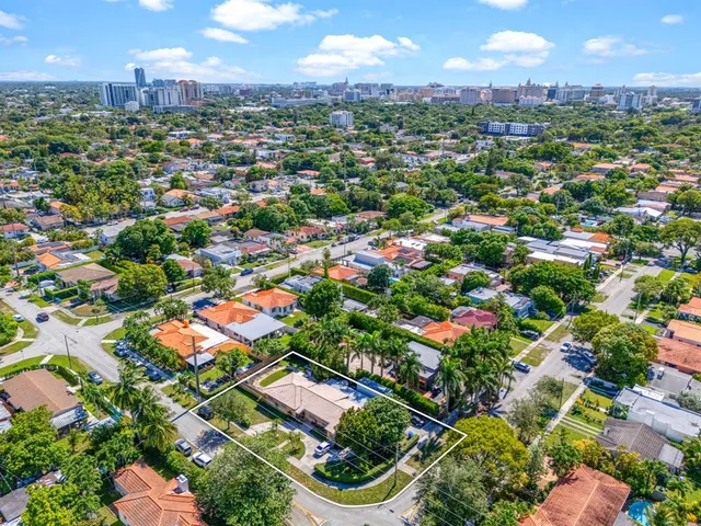 an aerial view of residential houses with outdoor space and trees