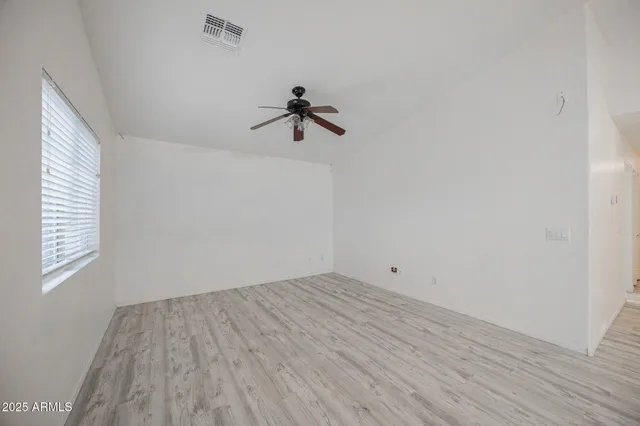 a view of room with hardwood floor and a ceiling fan