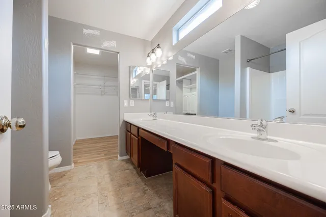 a bathroom with a double vanity sink mirror and shower
