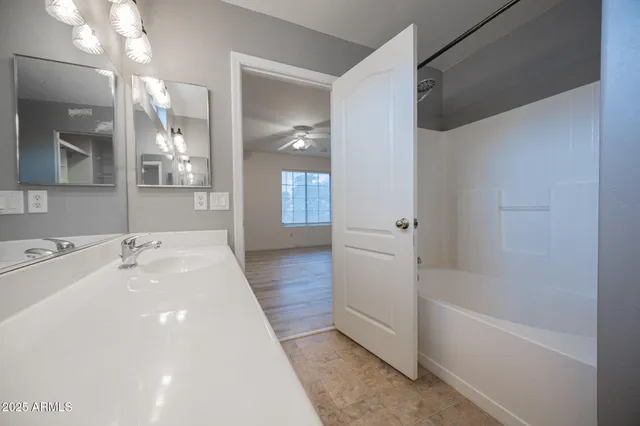 a spacious bathroom with a tub sink and mirror