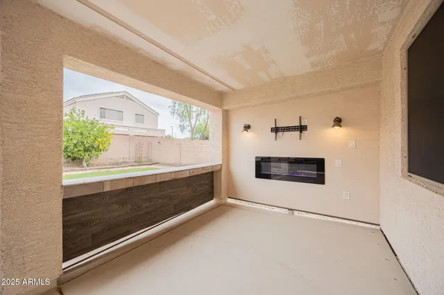 a view of an empty room with a window and a fireplace