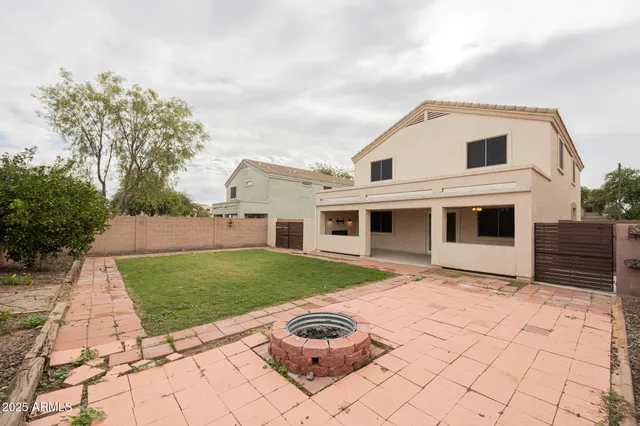 a front view of a house with a garden and trees