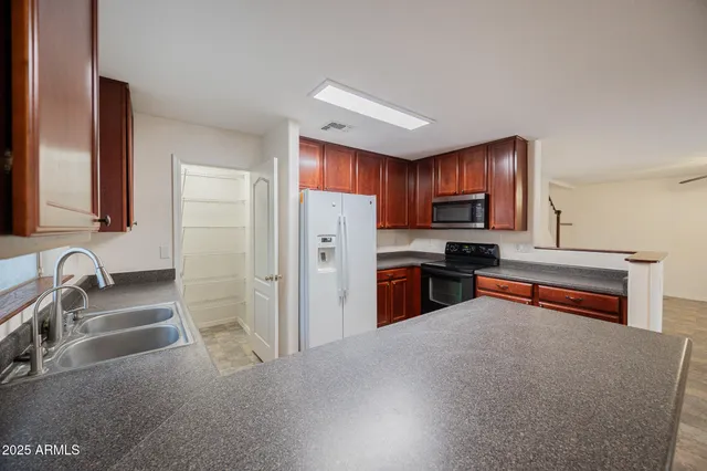 a kitchen with granite countertop a refrigerator and a sink