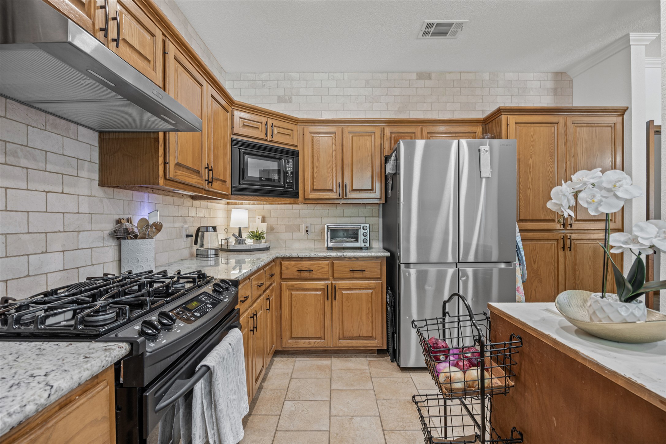 2000 Spinel Road Pflugerville, TX 78660 - Photo 9 of 31 Granite counters and light wood cabinetry define this well-appointed culinary space.