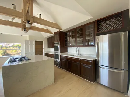 a kitchen with stainless steel appliances granite countertop a refrigerator a sink and a stove