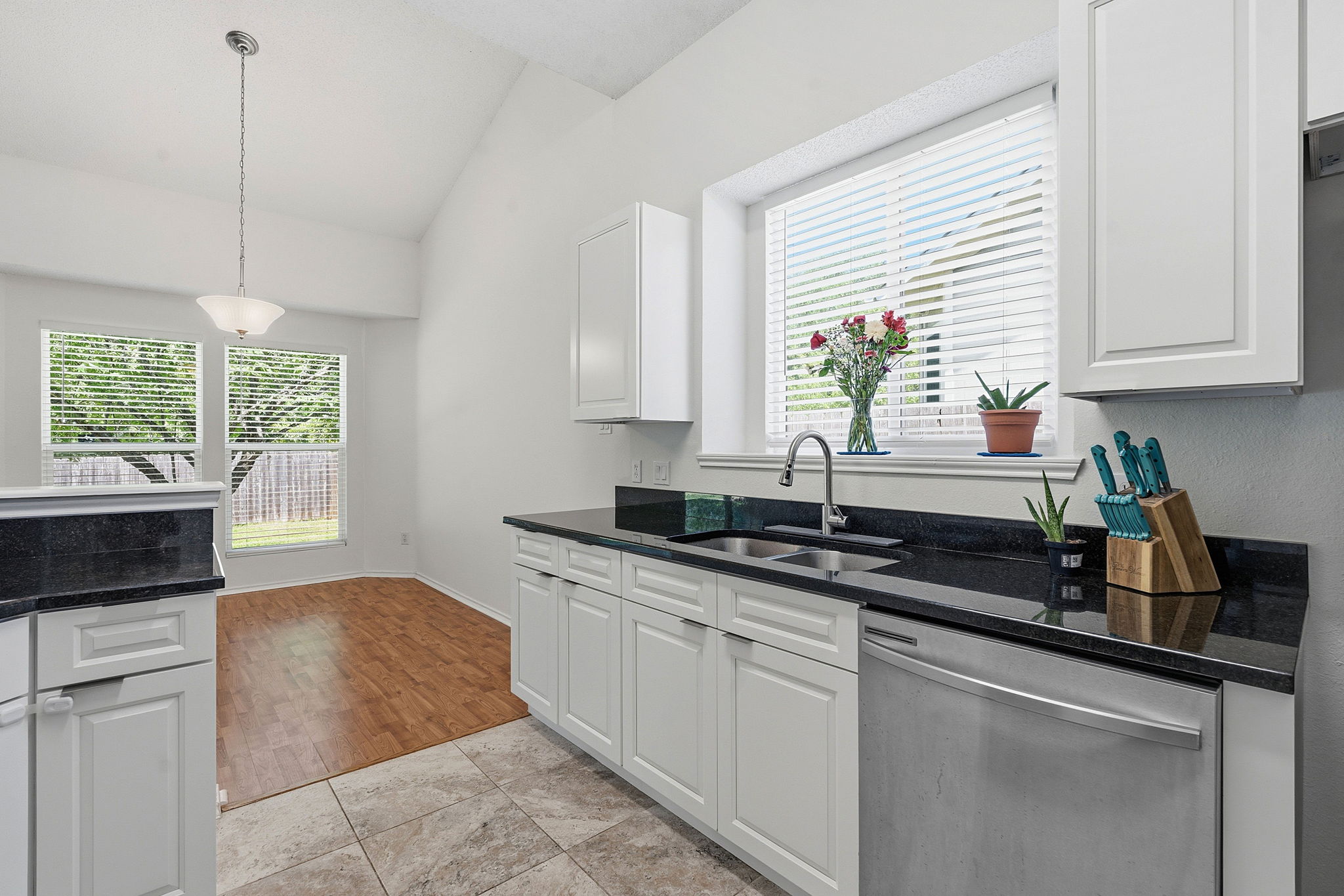 14818 Yellowleaf Trail Austin, TX 78728 - Photo 9 of 26 Kitchen area featuring white cabinetry, dark countertops, a stainless steel dishwasher, and a window above the sink