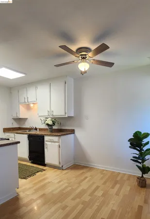 a view of a kitchen with a sink a ceiling fan and stainless steel appliances