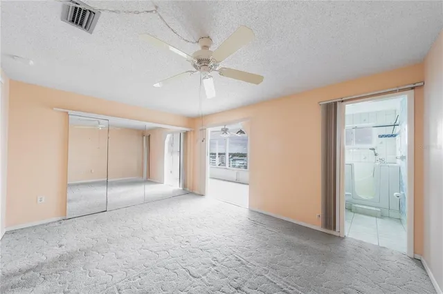 an empty room with fan and windows