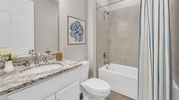 a bathroom with a granite countertop sink a toilet and shower