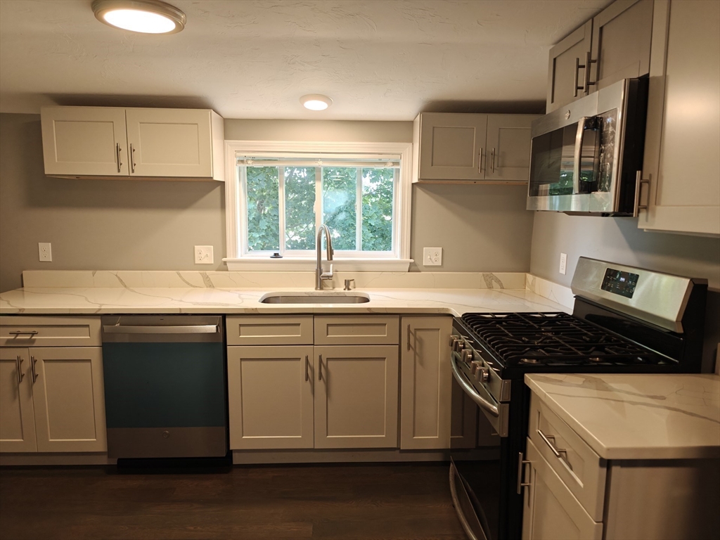 a kitchen with stainless steel appliances a sink stove and cabinets