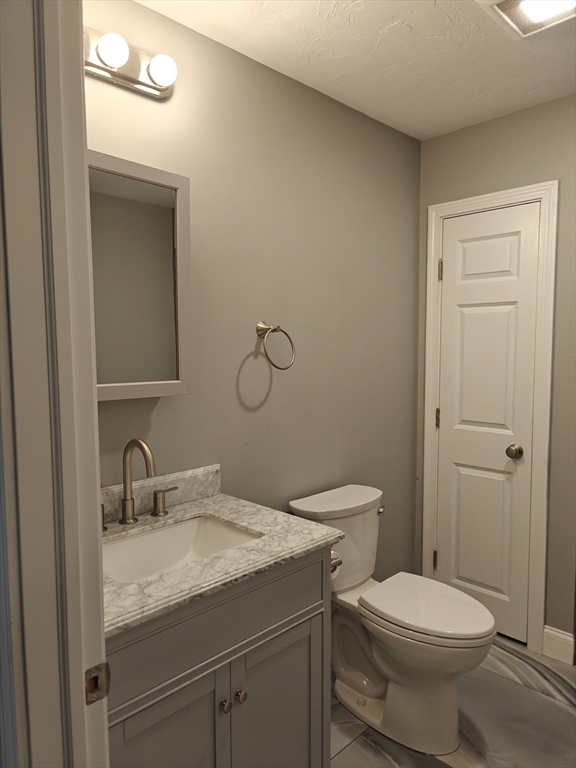105 Holyoke Street, Unit 2 Lynn, MA 01905 - Photo 12 of 20 a bathroom with a granite countertop toilet sink and mirror