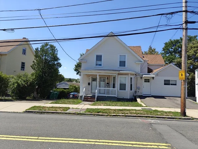 a view of a white house with a large pool in front of it