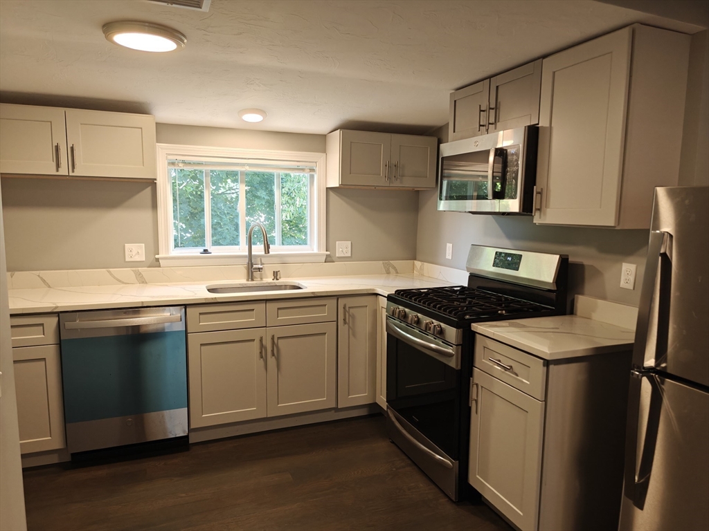 105 Holyoke Street, Unit 2 Lynn, MA 01905 - Photo 3 of 20 a kitchen with stainless steel appliances granite countertop a sink stove and microwave