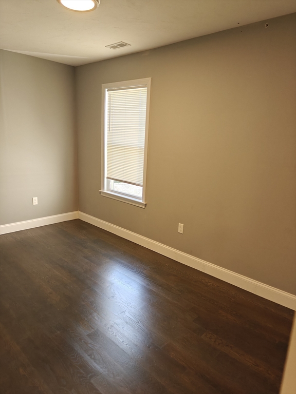 105 Holyoke Street, Unit 2 Lynn, MA 01905 - Photo 9 of 20 an empty room with wooden floor and windows