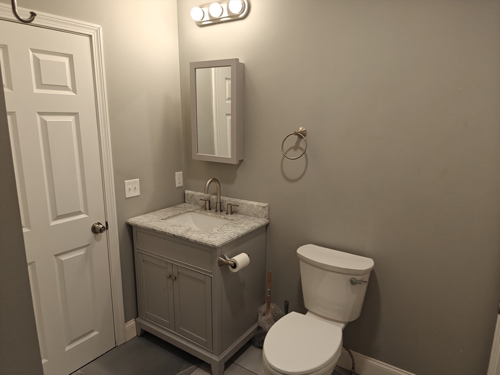 105 Holyoke Street, Unit 2 Lynn, MA 01905 - Photo 10 of 20 a bathroom with a granite countertop toilet and a sink