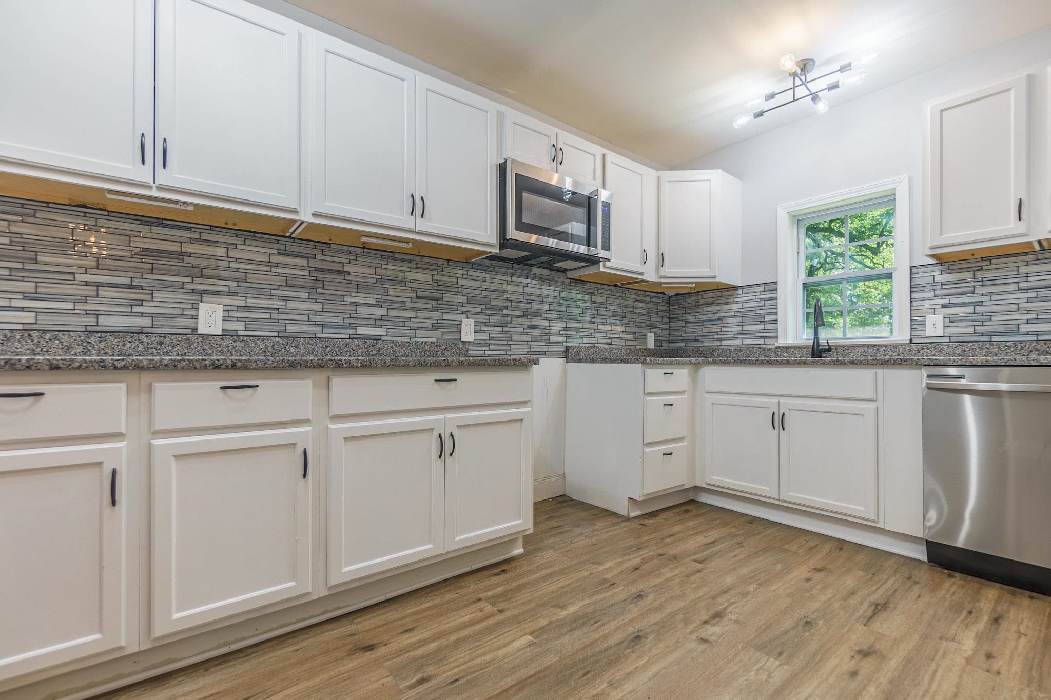 2418 Vanderbilt Road Memphis, TN 38106 - Photo 6 of 16 a kitchen with granite countertop white cabinets white appliances and a granite counter tops