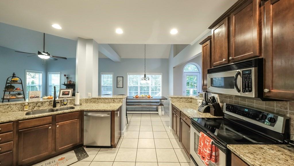 8680 Copperridge Drive Winston, GA 30187 - Photo 25 of 58 a large kitchen with stainless steel appliances granite countertop a stove sink and cabinets