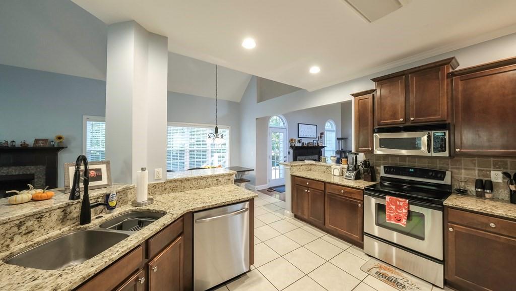 8680 Copperridge Drive Winston, GA 30187 - Photo 26 of 58 a kitchen with kitchen island granite countertop a sink stainless steel appliances and cabinets
