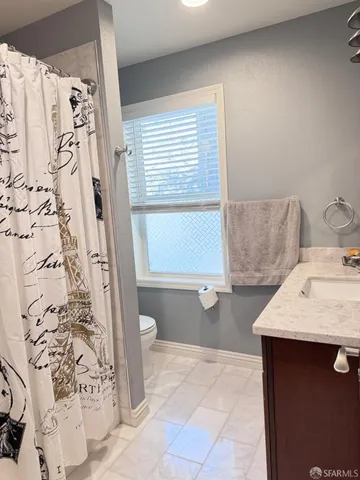 a bed sitting in a room next to a lamp with wooden floor