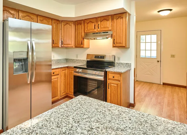 a kitchen with stainless steel appliances granite countertop a sink stove and refrigerator