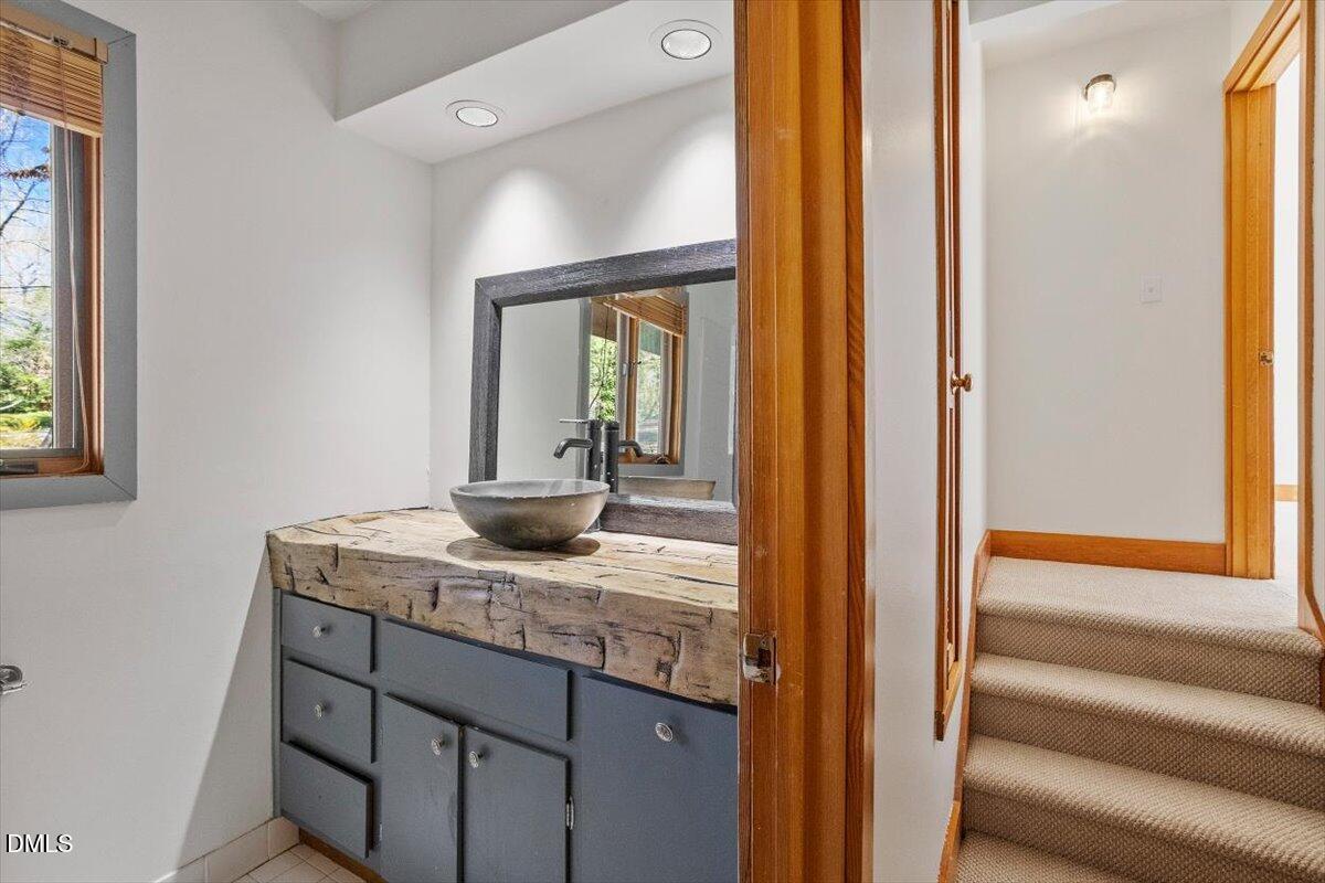 4805 Rembert Drive Raleigh, NC 27612 - Photo 21 of 45 a bathroom with a granite countertop sink and a mirror