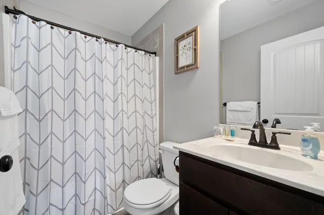 a bathroom with a sink a toilet and shower curtain