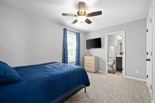 a bedroom with a bed and a flat tv screen on dresser