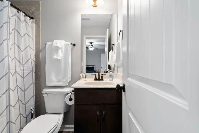 a bathroom with a sink a toilet and shower curtain
