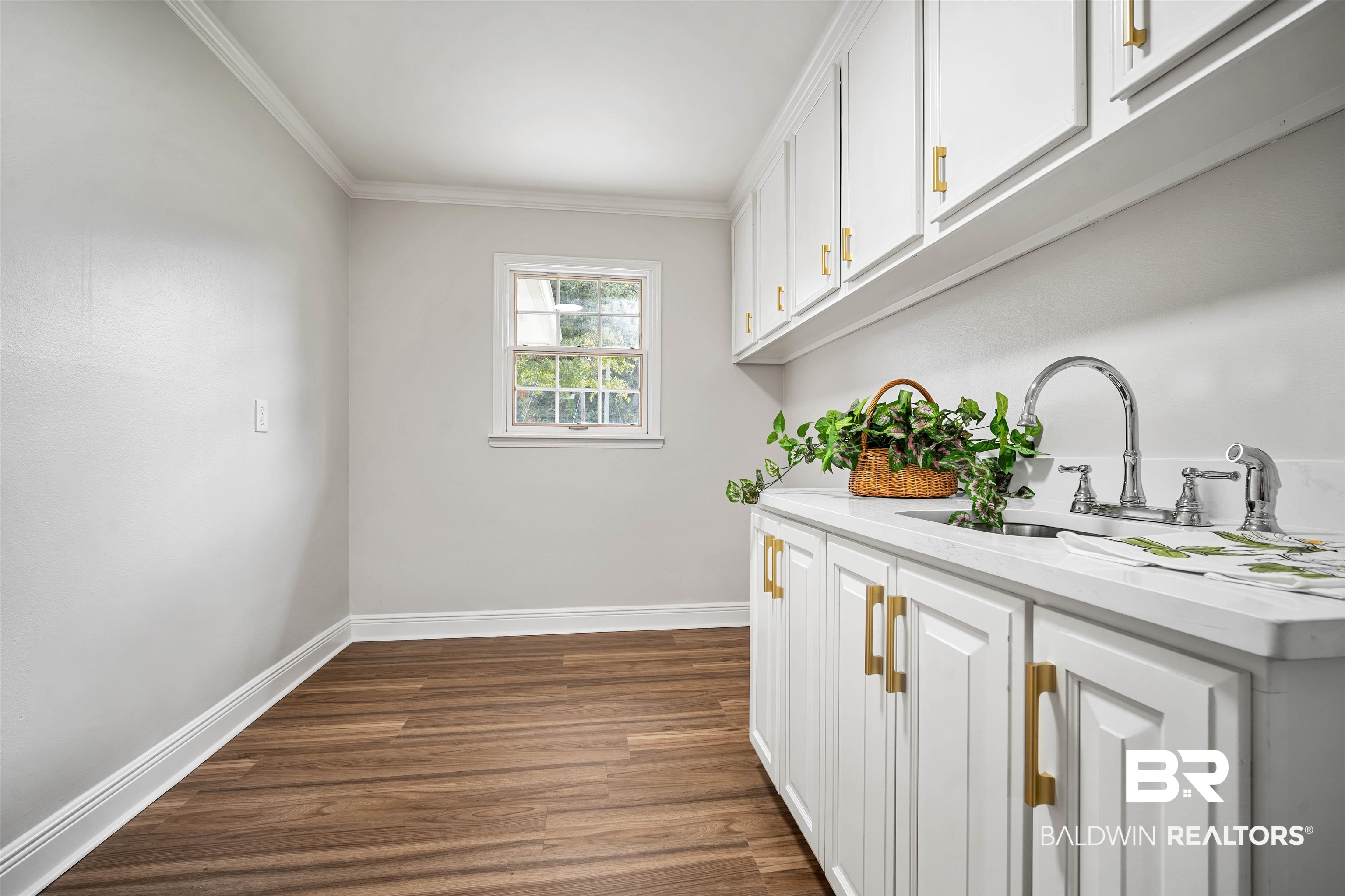 3050 Lacoste Road Mobile, AL 36618 - Photo 24 of 30 Washroom with ornamental molding, dark wood-style floors, and cabinet space