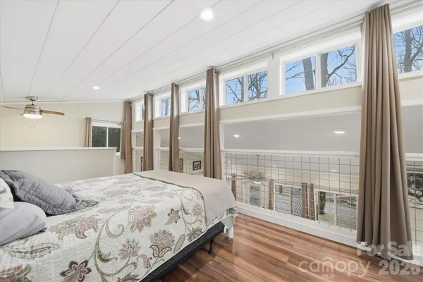 a bedroom with a large bed and a large window with outer view