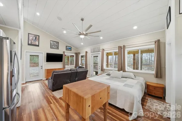 a spacious bedroom with a bed and a flat screen tv