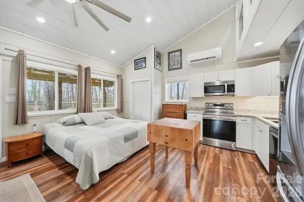 a bedroom with a bed and wooden floor