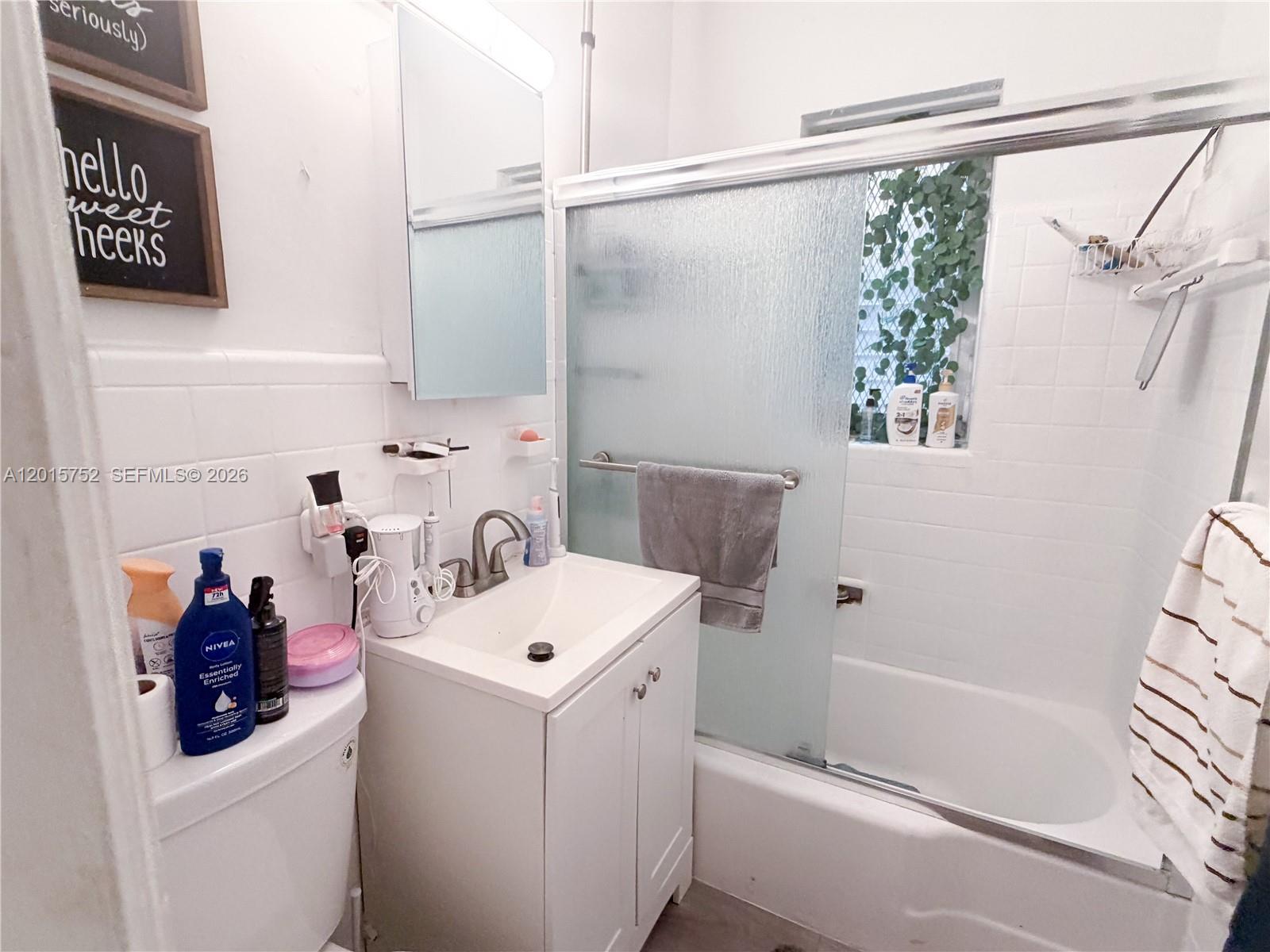 8144 Harding Avenue, Unit 2 Miami Beach, FL 33141 - Photo 11 of 18 a bathroom with a sink a toilet and shower
